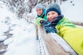 Boy takes self photo with his father on winter walk in mountain