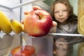 Boy taking apple out of fridge, children diet concept Royalty Free Stock Photo