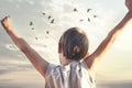 Boy taking a breath with open arms in front of a wonderful sunset