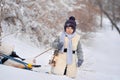 The boy is taking his teddy bear on a sledge to visit Santa Claus.