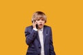 The boy is talking on his mobile phone with a serious expression. Royalty Free Stock Photo