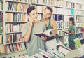 Boy talking on mobile phone while buying books with friend in st Royalty Free Stock Photo