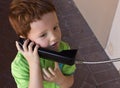 Boy talking on public telephone