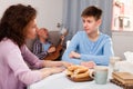 Boy talking to mother on background with indifferent father