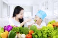 Boy tasting salad in kitchen