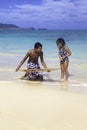 Boy teaching sister to skim board Royalty Free Stock Photo