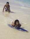 Boy teaching sister to skim board Royalty Free Stock Photo