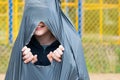 Boy tears a black trash bag from the inside, sitting in it