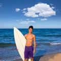 Boy teen surfer happy holing surfboard on the beach Royalty Free Stock Photo