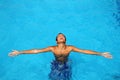 Boy teenage relaxed open arms blue swimming pool Royalty Free Stock Photo
