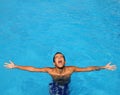 Boy teenage relaxed open arms blue swimming pool Royalty Free Stock Photo