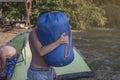 Boy teenager carrying bag with tent in summer campsite.