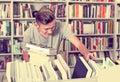 Boy teenager choosing new book in shop