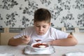 Boy teenager eating soup at kitchen table