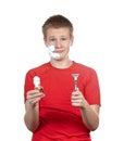 The boy, the teenager the first time tries to have a shave and is confused.Portrait on a white background