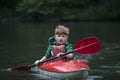 Boy teenager manages a canoe kayak on a wide river. Royalty Free Stock Photo