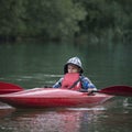 Boy teenager manages a canoe kayak on a wide river. Royalty Free Stock Photo