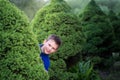 Boy teenager peeking out of a bush