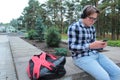 Boy teenager schoolboy or student in a shirt, smiles in glasses, listens to music on the phone Royalty Free Stock Photo