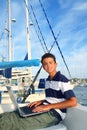 Boy teenager seat on boat marina laptop computer Royalty Free Stock Photo