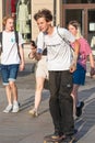 Boy or teenager skateboarding in the city and using smartphone