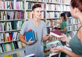 Boy teenager taking new book from seller in book store