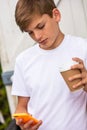 Boy teenager teen male child using cell phone and drinking coffee or tea Royalty Free Stock Photo