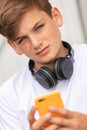 Boy teenager teen male child using cell phone and headphones Royalty Free Stock Photo