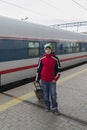 Boy teenager with travel bag near a train