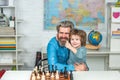 Boy think or plan about chess game - style for education concept. Man teacher play chess with preschooler child.