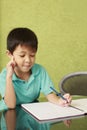 Boy thinking while doing homework. Conceptual image Royalty Free Stock Photo