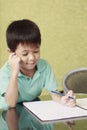 Boy thinking while doing homework. Conceptual image Royalty Free Stock Photo