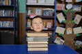 Boy thinking lying head on pile of books in library, putting head on pile of book Royalty Free Stock Photo