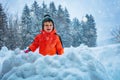 Boy throw snowball standing in the snow fortress over mountains Royalty Free Stock Photo