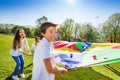 Boy throwing balls up by using rainbow parachute Royalty Free Stock Photo