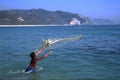 Boy throwing the fishnet into the ocean, pacific coast, Mexico