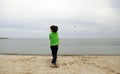 A boy throwing stone into the sea