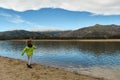 A boy throwing stones into the water from the shore of a lake. Royalty Free Stock Photo