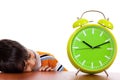 Boy tired of study and sleeping near the clock