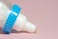 A boy toddler infant drinking a milk of bottle. Isolated on pink background.