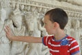 A boy touches historical monument