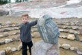 Boy touching face carved in stone