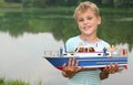 Boy with toy ship in hands ashore