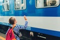 Boy on the train station wave goodbye. Kid with backpack on a subway Royalty Free Stock Photo