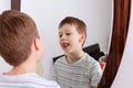 Portrait of a boy. He stands in front of the mirror and is done.