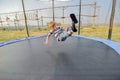 The boy on the trampoline jumps to the top with his feet, wide-angle photo Royalty Free Stock Photo