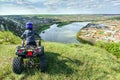 The boy is traveling on an ATV. Beautiful view