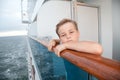 Boy traveling on ship and hold on handrails