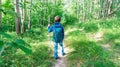 A boy with a trekking pole and a backpack walks along a tourist route, participating in orienteering competitions. the child goes