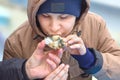 The boy tries a live oyster for the first time, dad gives him a shell in his hand. The relationship of father and son